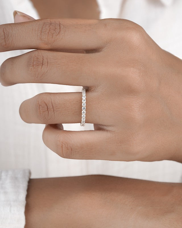  Hand wearing full eternity diamond ring band in yellow gold.