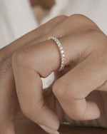  Hand wearing full eternity diamond ring band in yellow gold