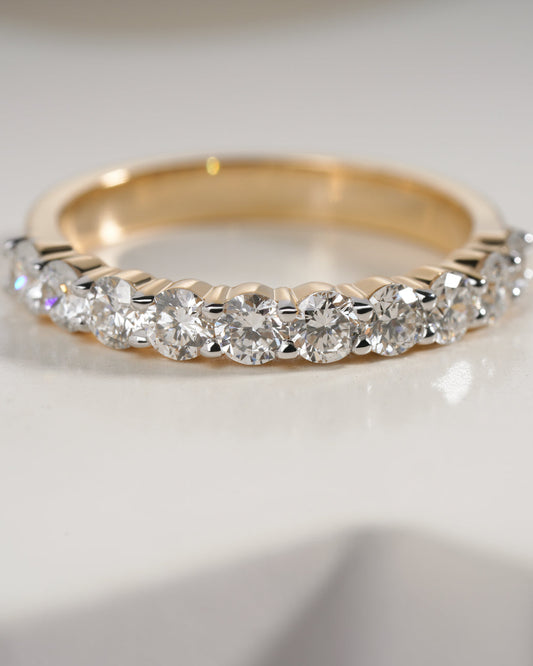 Half eternity Gold ring with diamonds on a light background.