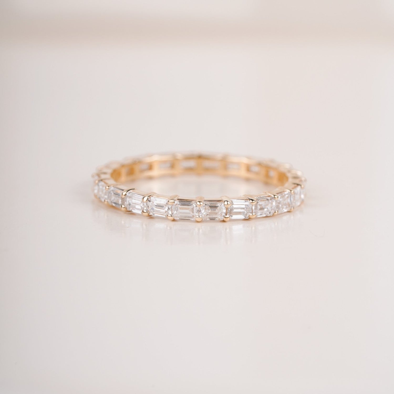Close up shot of half eternity diamond ring in yellow gold.