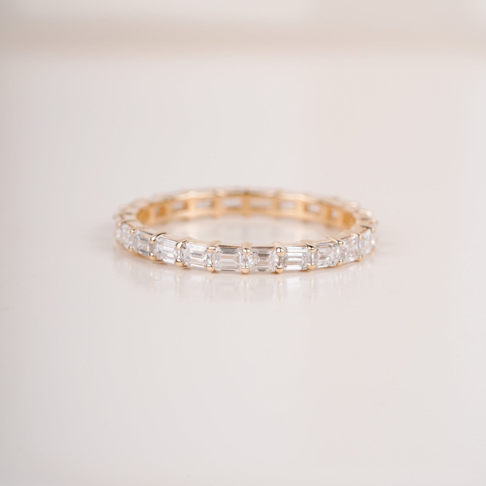 Close up shot of half eternity diamond ring in yellow gold.