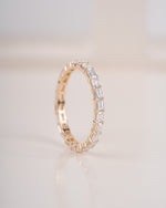 Close up shot of half eternity diamond ring in yellow gold.