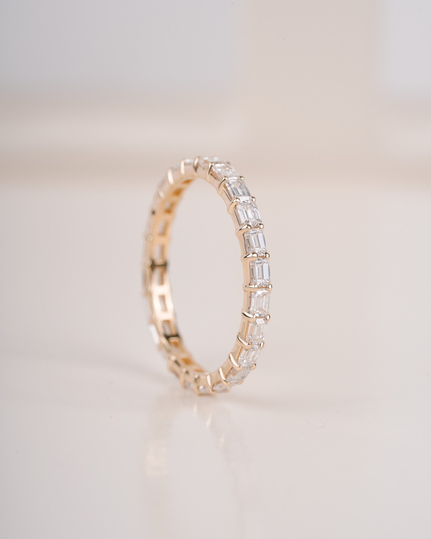 Close up shot of half eternity diamond ring in yellow gold.