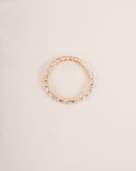 Close up shot of half eternity diamond ring in yellow gold.