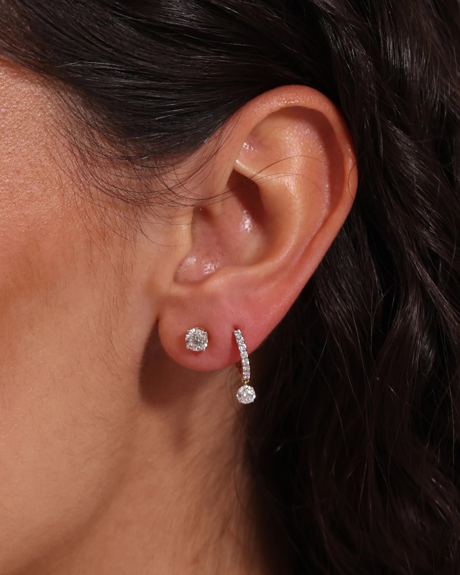 Close up of diamond drop hoop earrings.