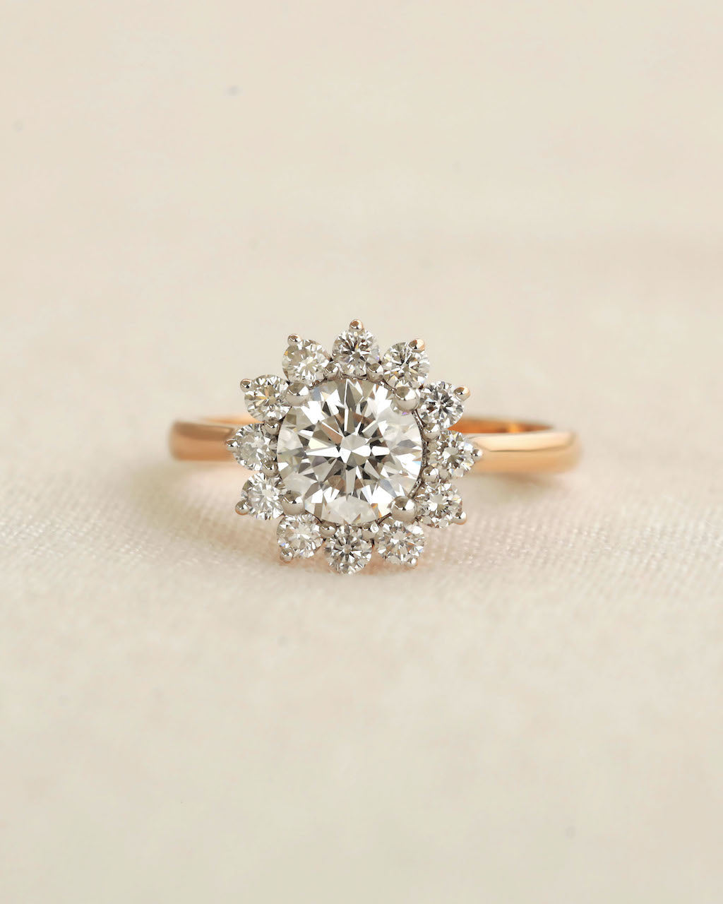 Gold ring with a diamond on a beige background.