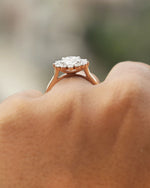 Rose gold ring with a heart-shaped diamond cluster on a blurred background.