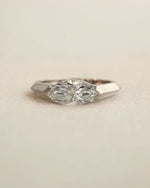 Marquise cut diamond bezel ring in white gold on white background.