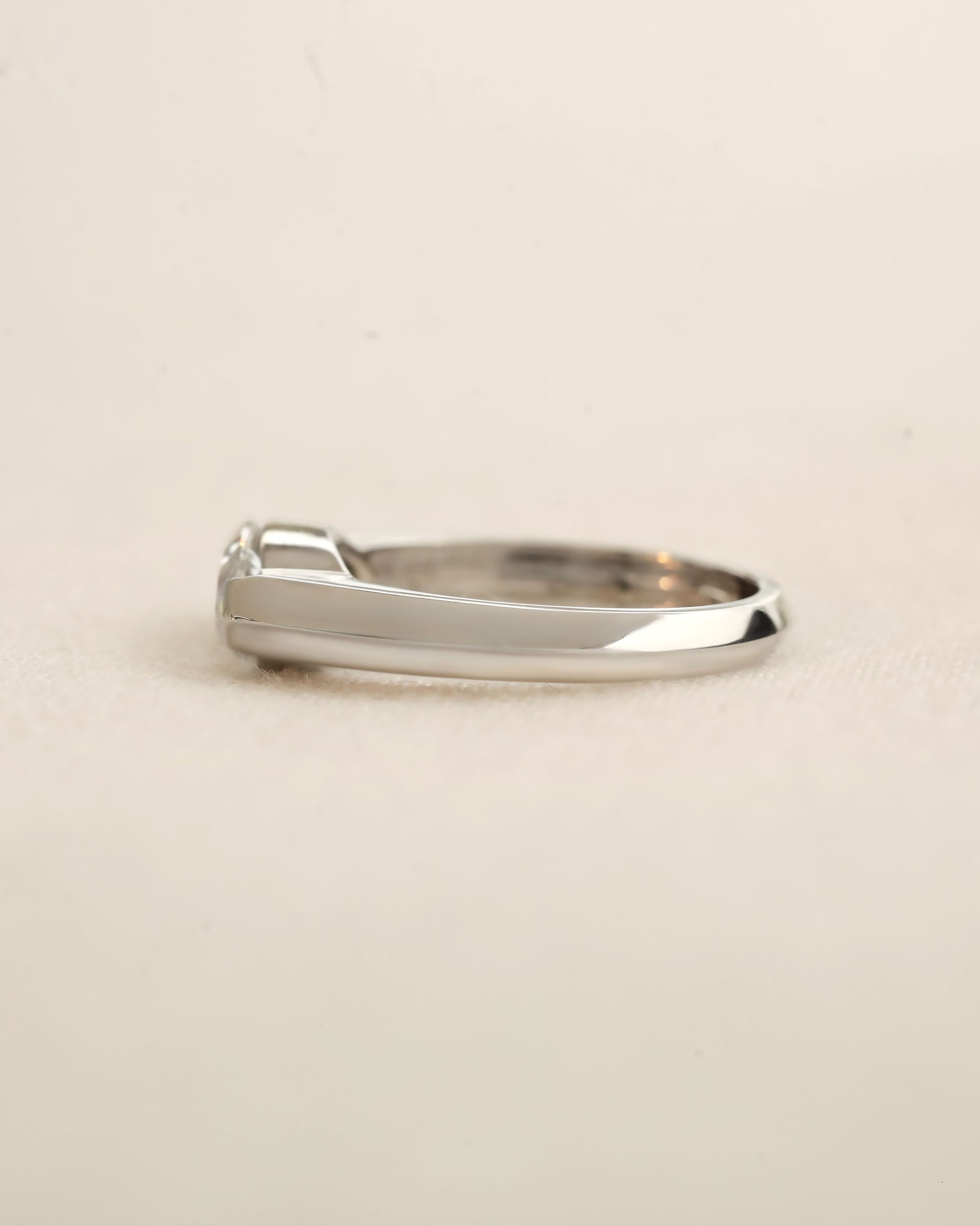 Side view of marquise cut diamond bezel ring in white gold. 
