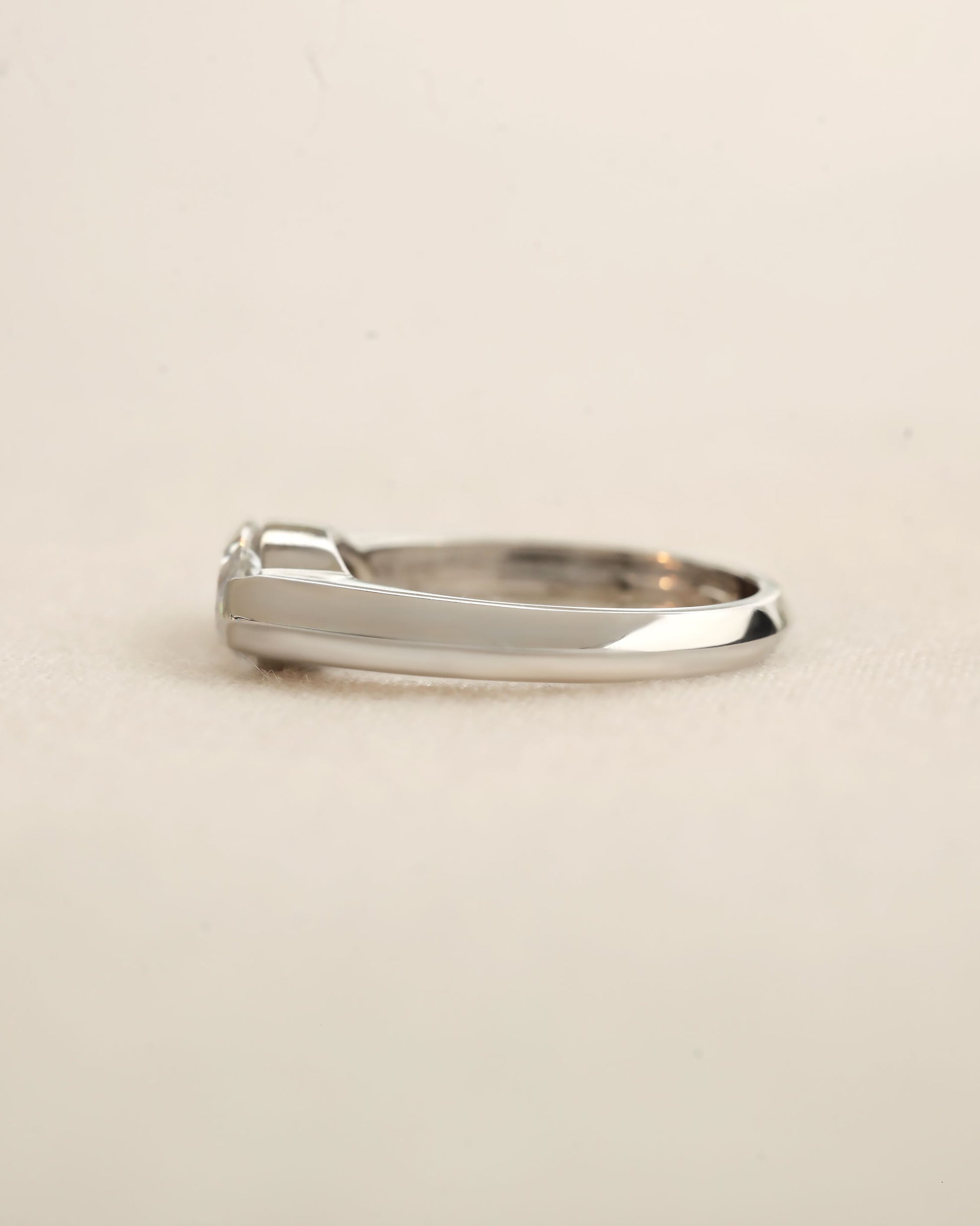 Side view of marquise cut diamond bezel ring in white gold. 