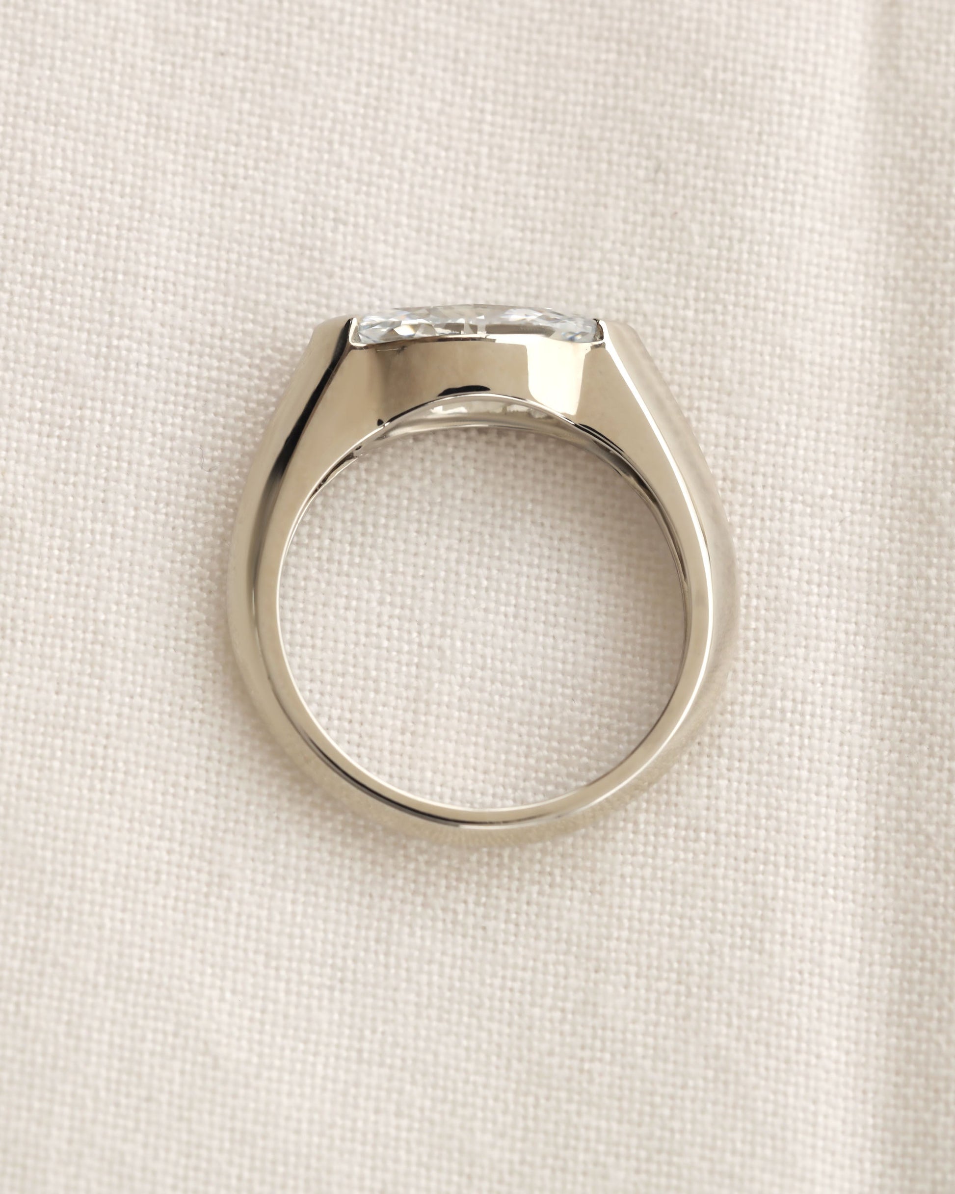 Close up shot of marquise cut diamond bezel ring in white gold. 