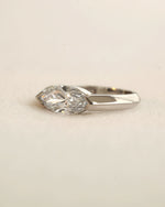 Marquise cut diamond bezel ring in white gold on white background.