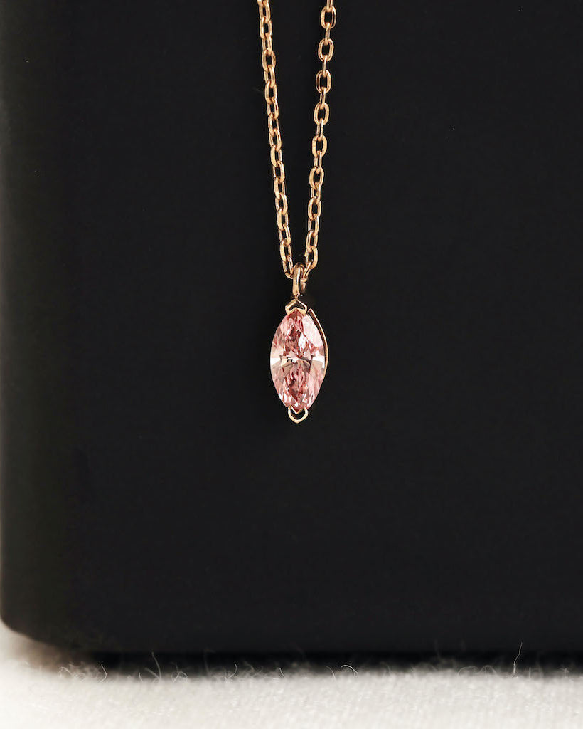 Close up shot of marquise cut lab diamond solitaire pendant necklace in yellow gold.