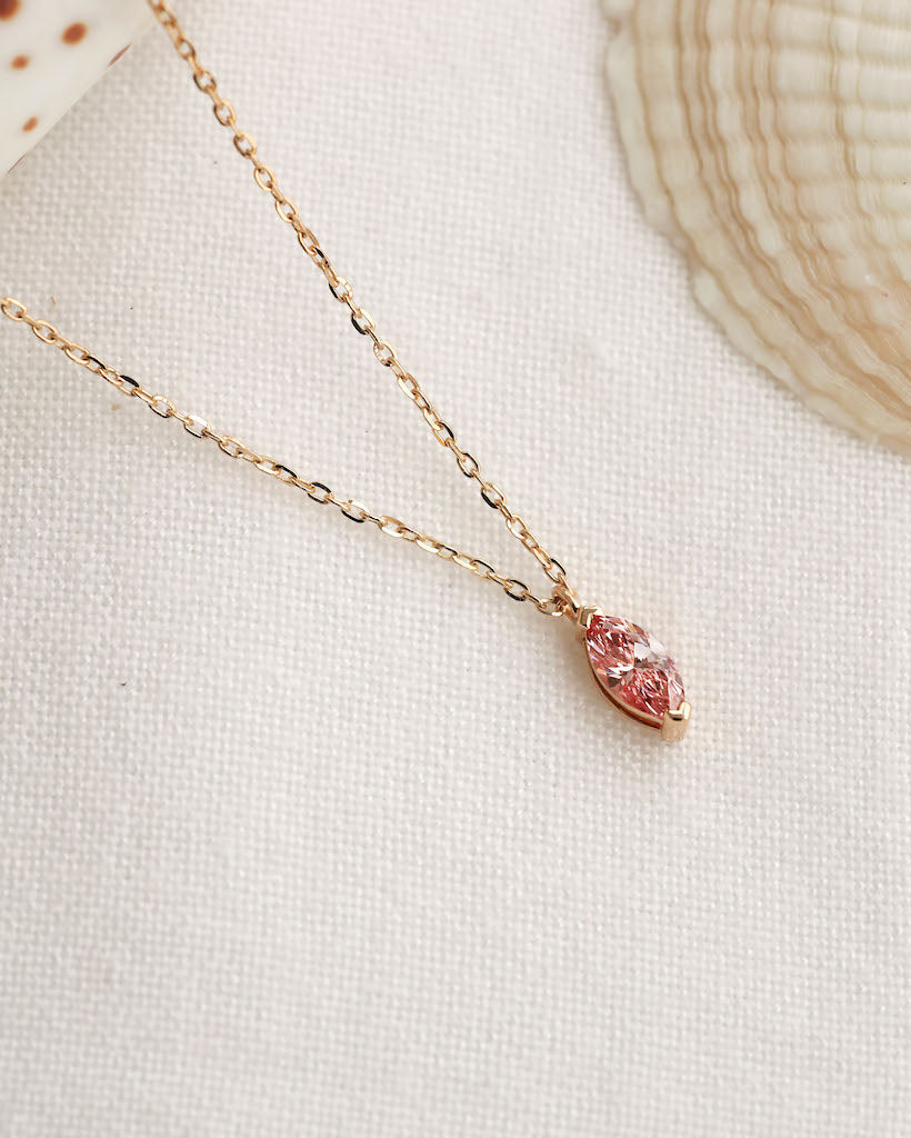 Close up shot of marquise cut lab diamond solitaire pendant necklace in yellow gold.