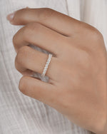 Hand wearing marquise eternity ring in yellow gold.