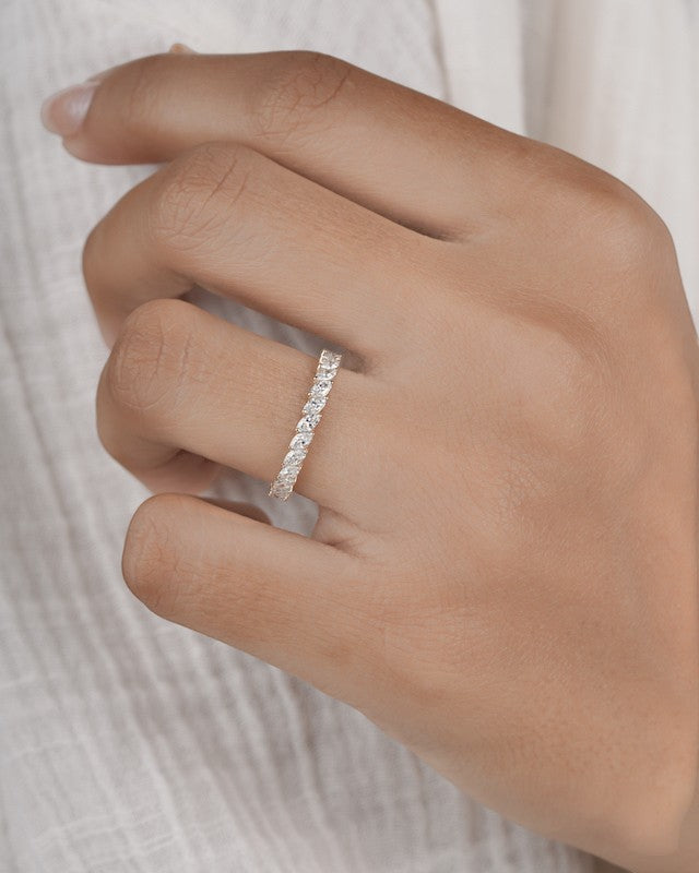 Hand wearing marquise eternity ring in yellow gold.