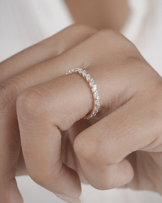 Hand wearing marquise eternity ring in yellow gold.