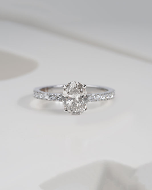 Close up shot of oval cut lab grown diamond engagement ring in white gold.