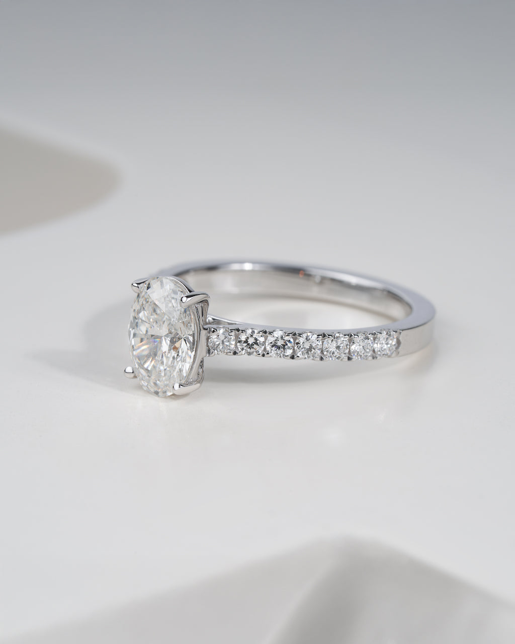 Close up shot of oval cut lab grown diamond engagement ring in white gold.