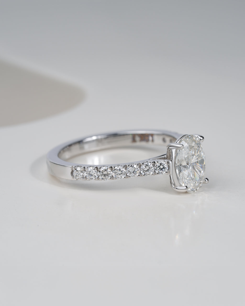 Close up shot of oval cut lab grown diamond engagement ring in white gold.