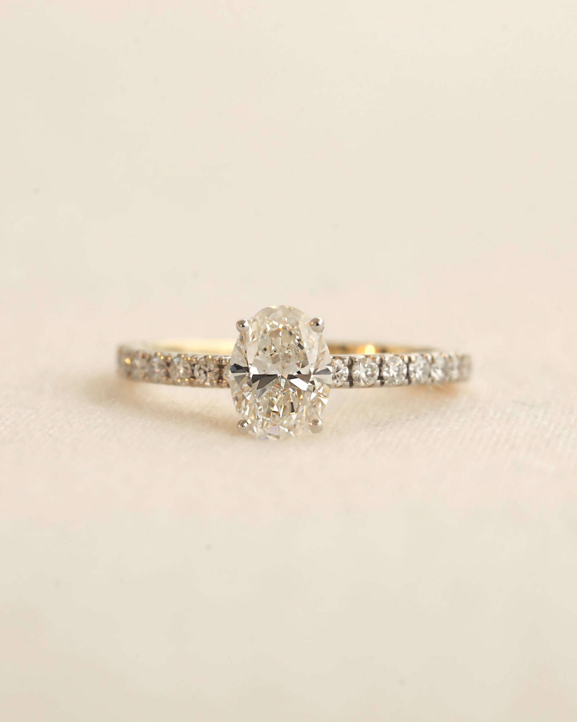 Close u shot of oval cut lab-grown diamond engagement ring in yellow gold.
