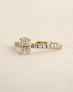 Close u shot of oval cut lab-grown diamond engagement ring in yellow gold.
