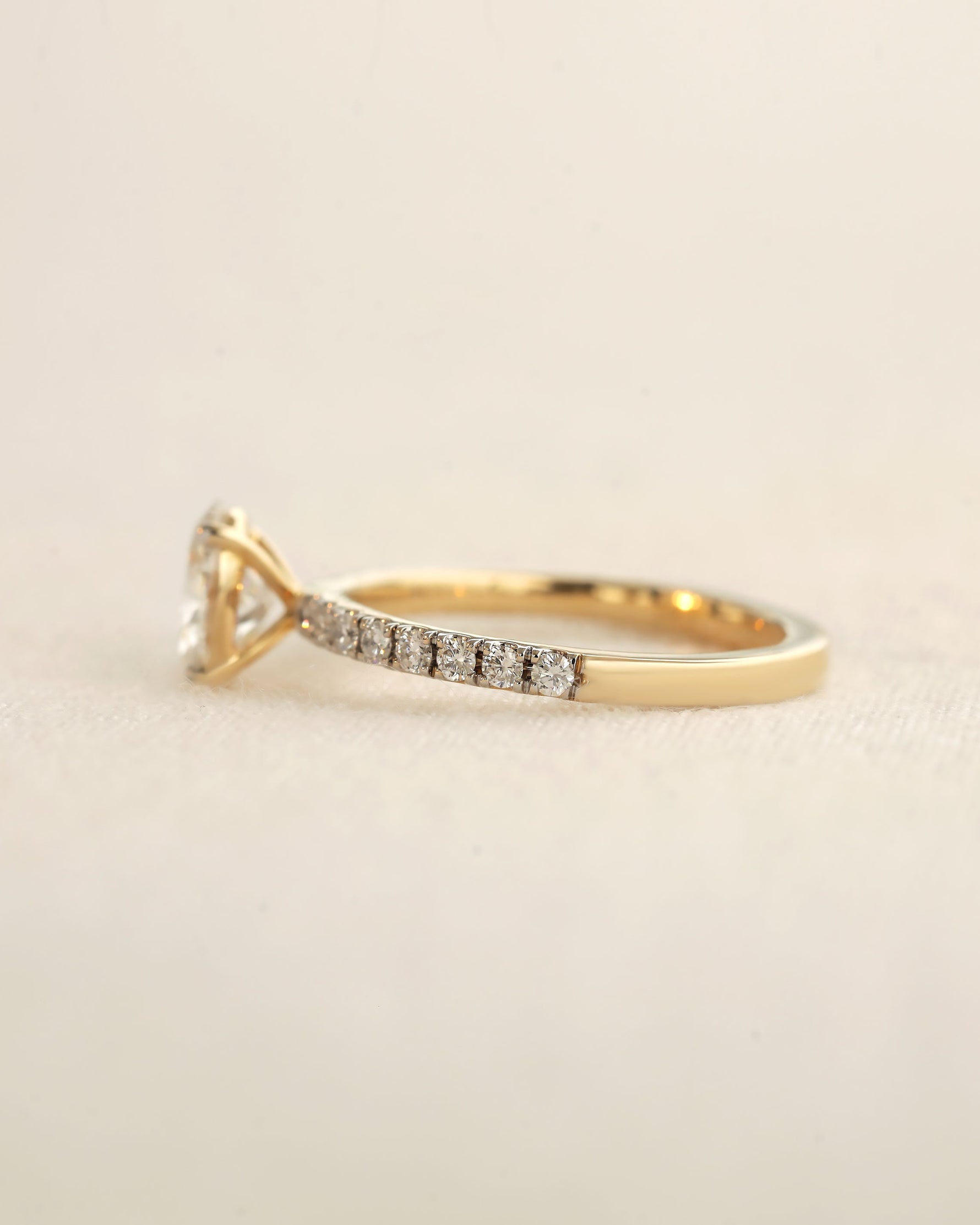 Side view of oval cut lab-grown diamond engagement ring in yellow gold.
