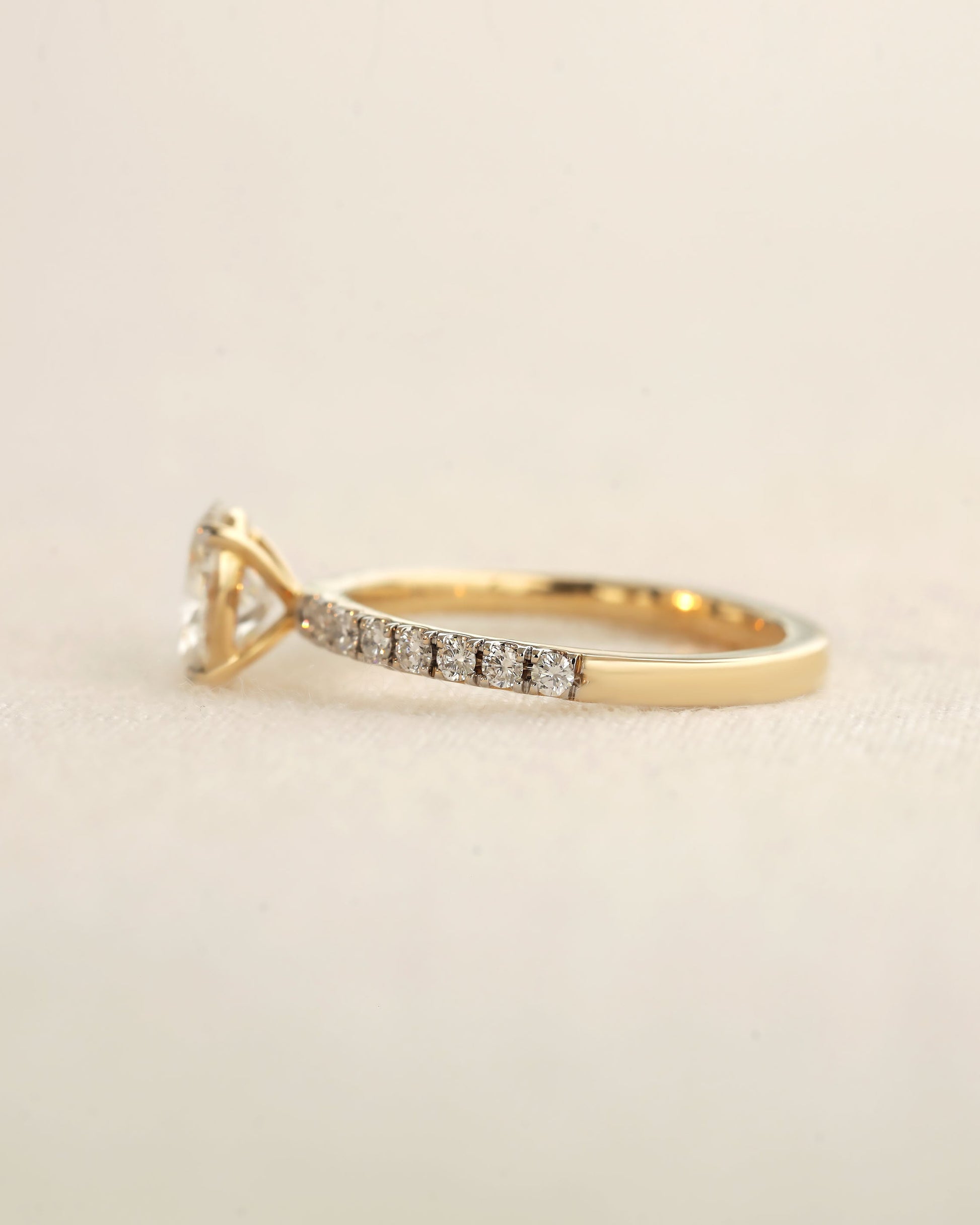 Side view of oval cut lab-grown diamond engagement ring in yellow gold.
