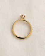 Close up shot of  oval cut lab-grown diamond engagement ring in yellow gold.
