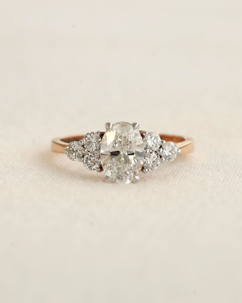 Close u shot of oval cut diamond engagement ring in rose gold.
