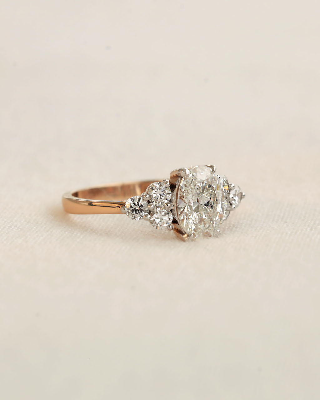 Side view of oval cut diamond engagement ring in rose gold.
