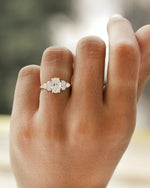 Hand wearing oval cut diamond engagement ring in rose gold.