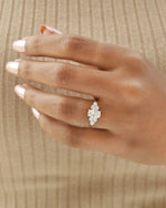 Hand wearing oval cut diamond engagement ring in rose gold.