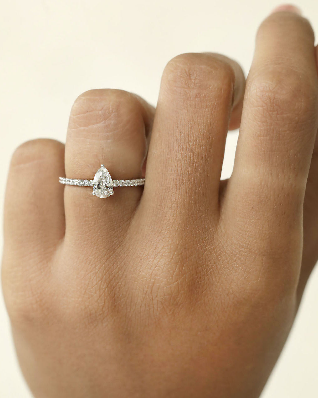 Hand wearing pear cut lab grown diamond ring.