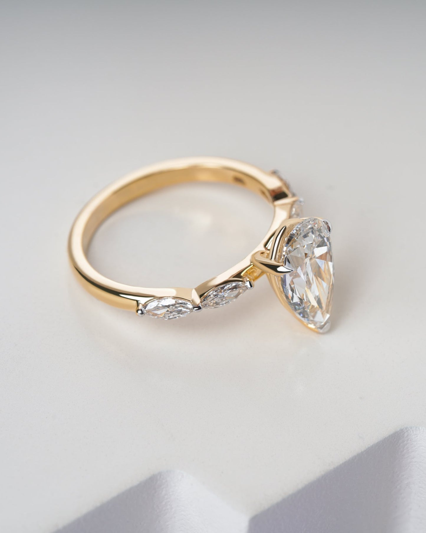 Gold ring with a diamond on a light gray background