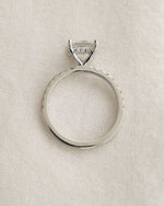 Close up shot of princess cut diamond ring displayed on a white background.