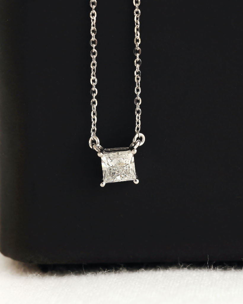 Close up shot of princess cut lab diamond solitaire pendant necklace in yellow gold.