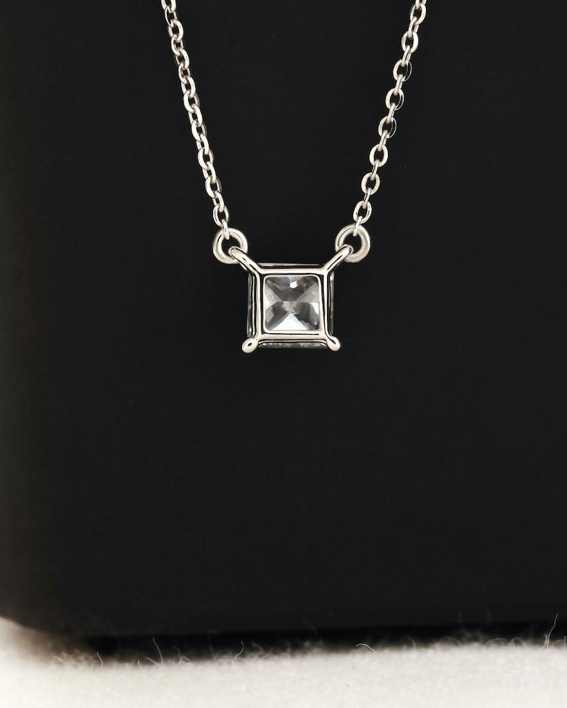 Close up shot of princess cut lab diamond solitaire pendant necklace in yellow gold.
