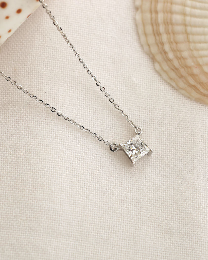 Close up shot of princess cut lab diamond solitaire pendant necklace in yellow gold.