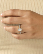 Hand wearing a diamond ring on  beige background