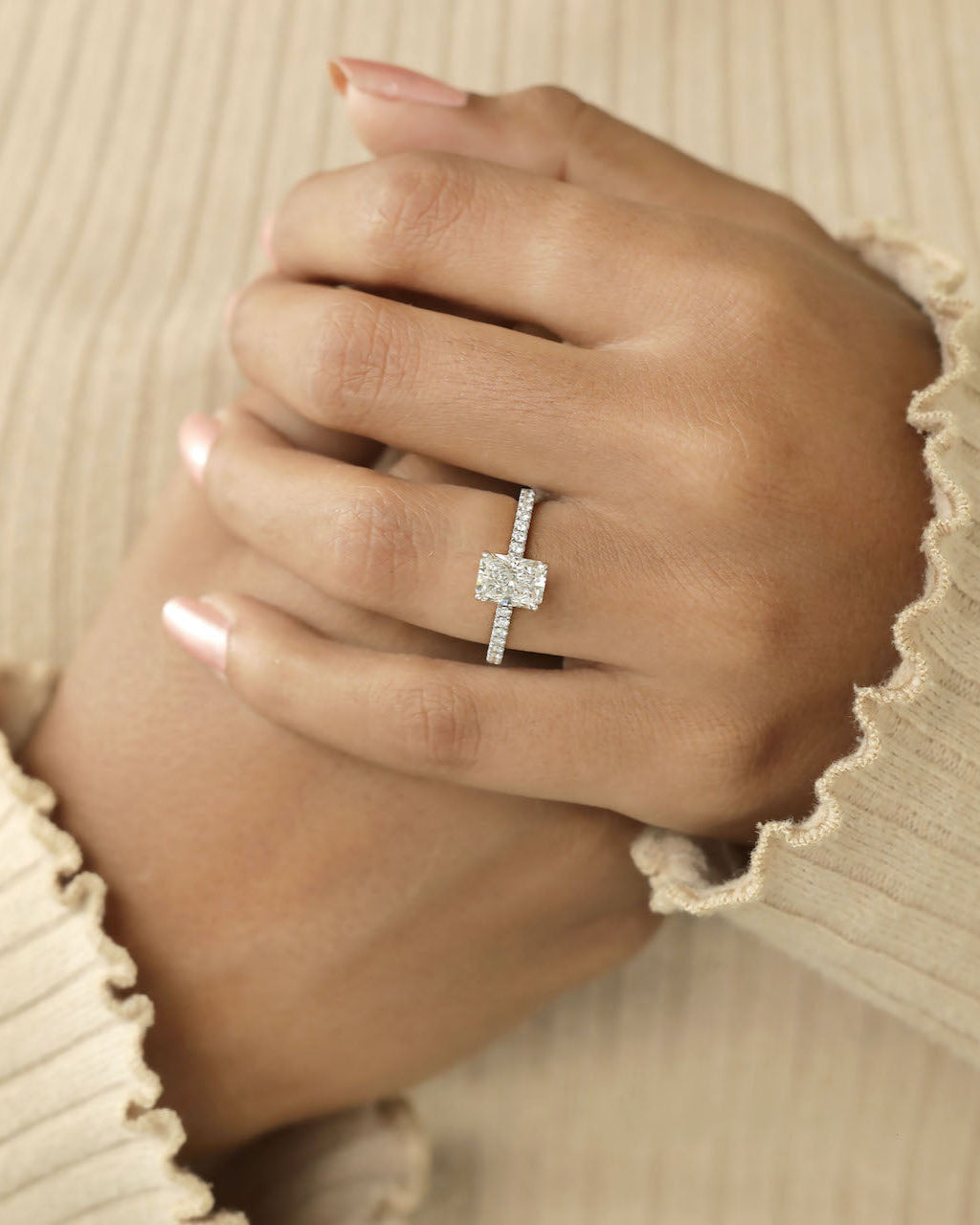 A close up shot of a person hand's,with one hand resting on other wearing a diamond ring. 