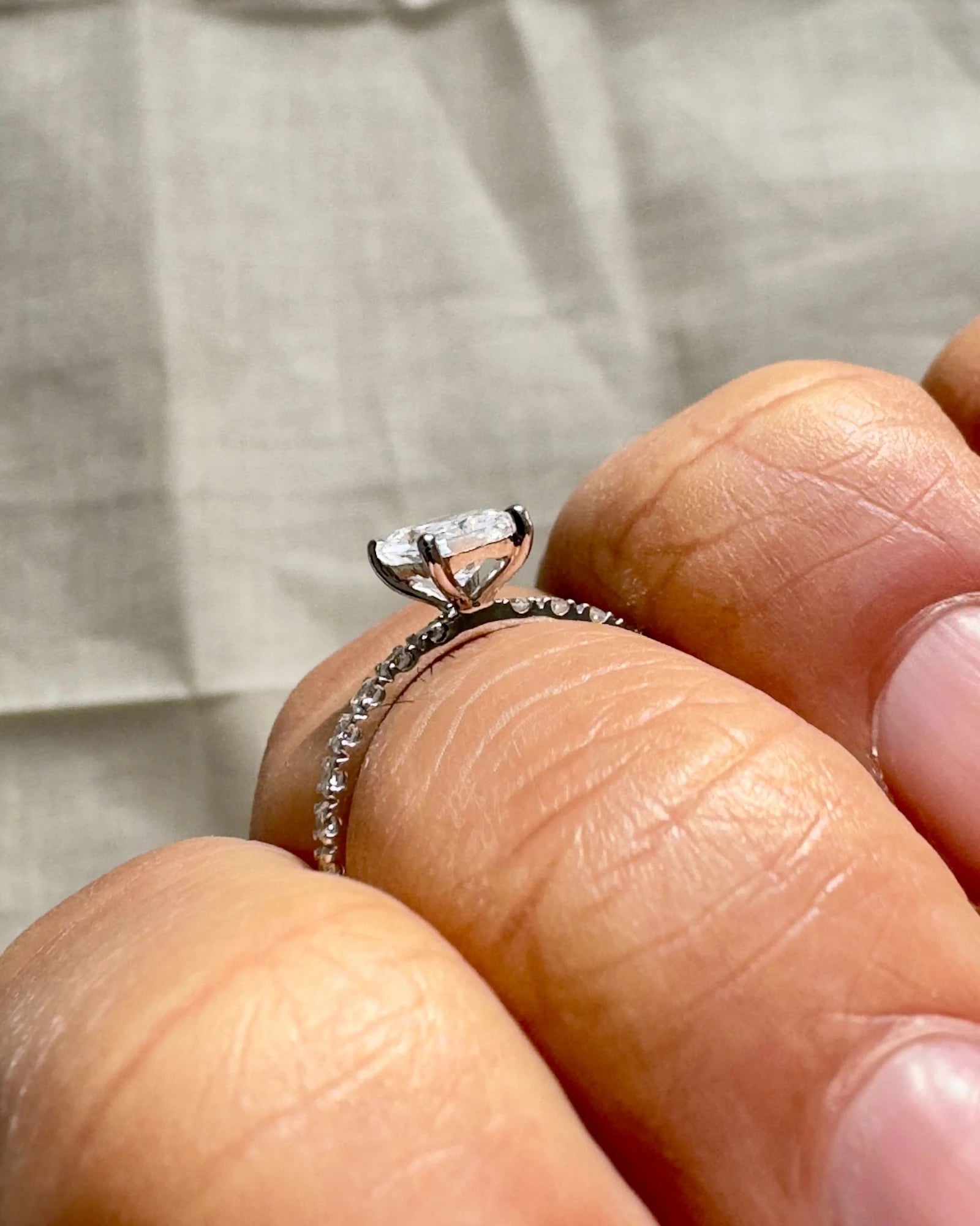 Hand wearing radiant cut diamond ring.