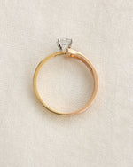 Close up of a yellow & rose gold round cut lab grown diamond ring with modern split v band.