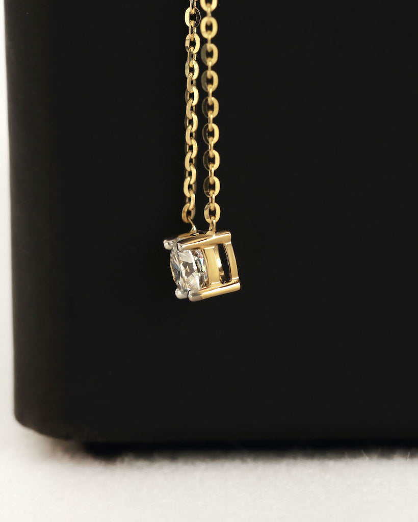 Close up shot of round cut lab diamond solitaire pendant necklace in yellow gold.