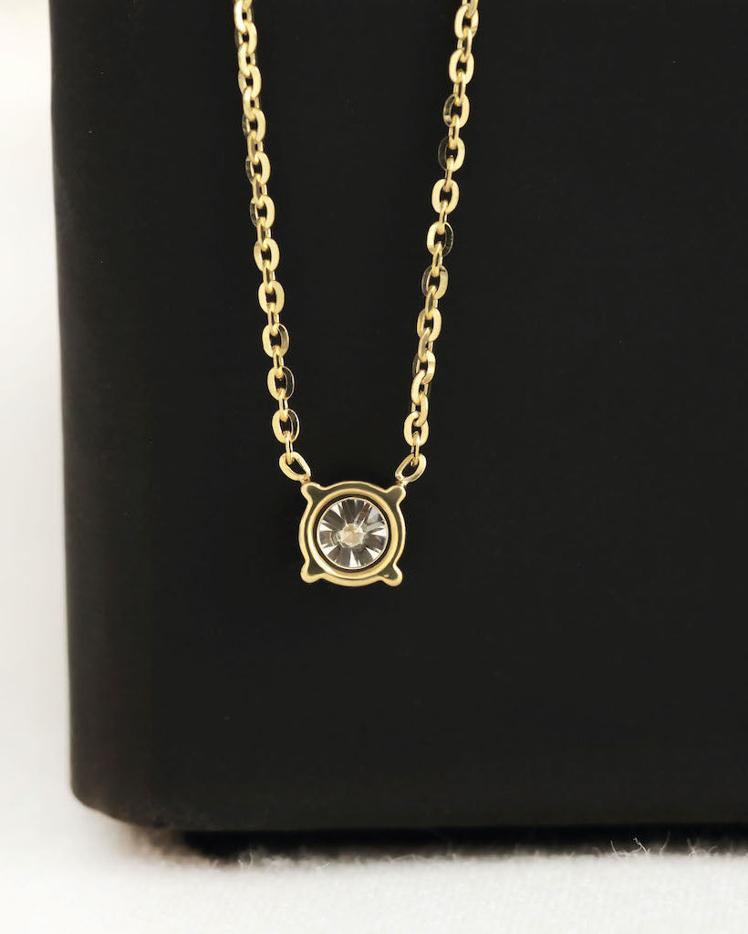 Close up shot of round cut lab diamond solitaire pendant necklace in yellow gold.