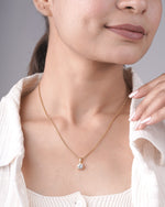 Round cut lab grown diamond solitaire pendant styled on a chain.