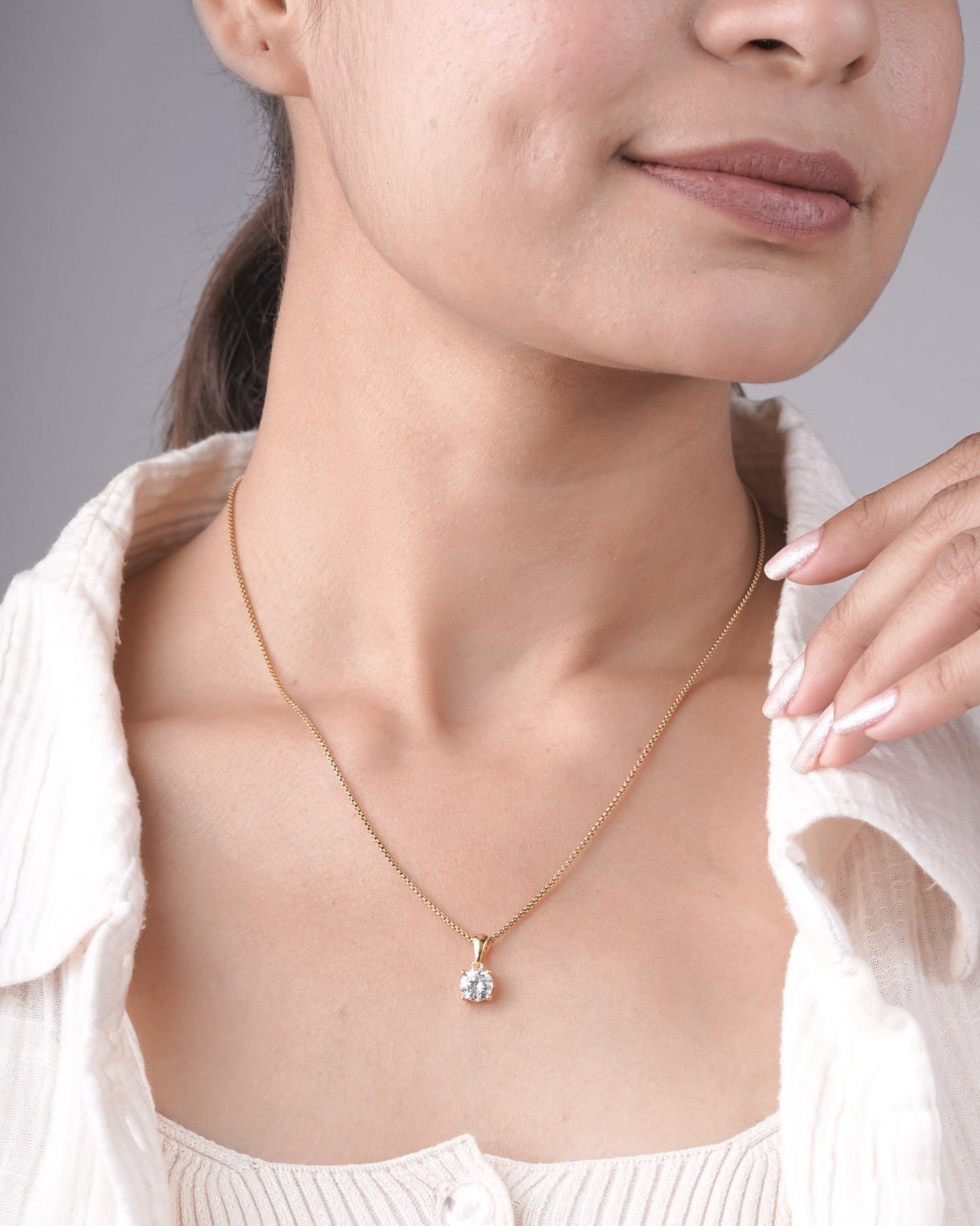 Round cut lab grown diamond solitaire pendant styled on a chain.