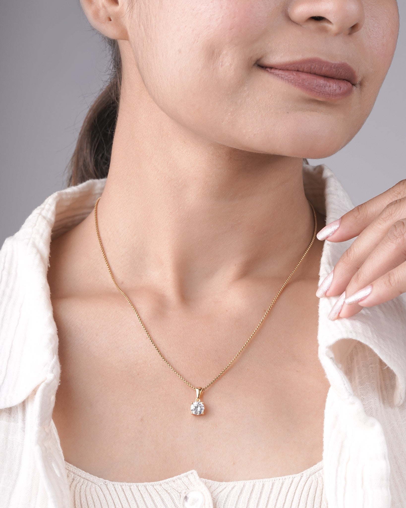 Round cut lab grown diamond solitaire pendant styled on a chain.