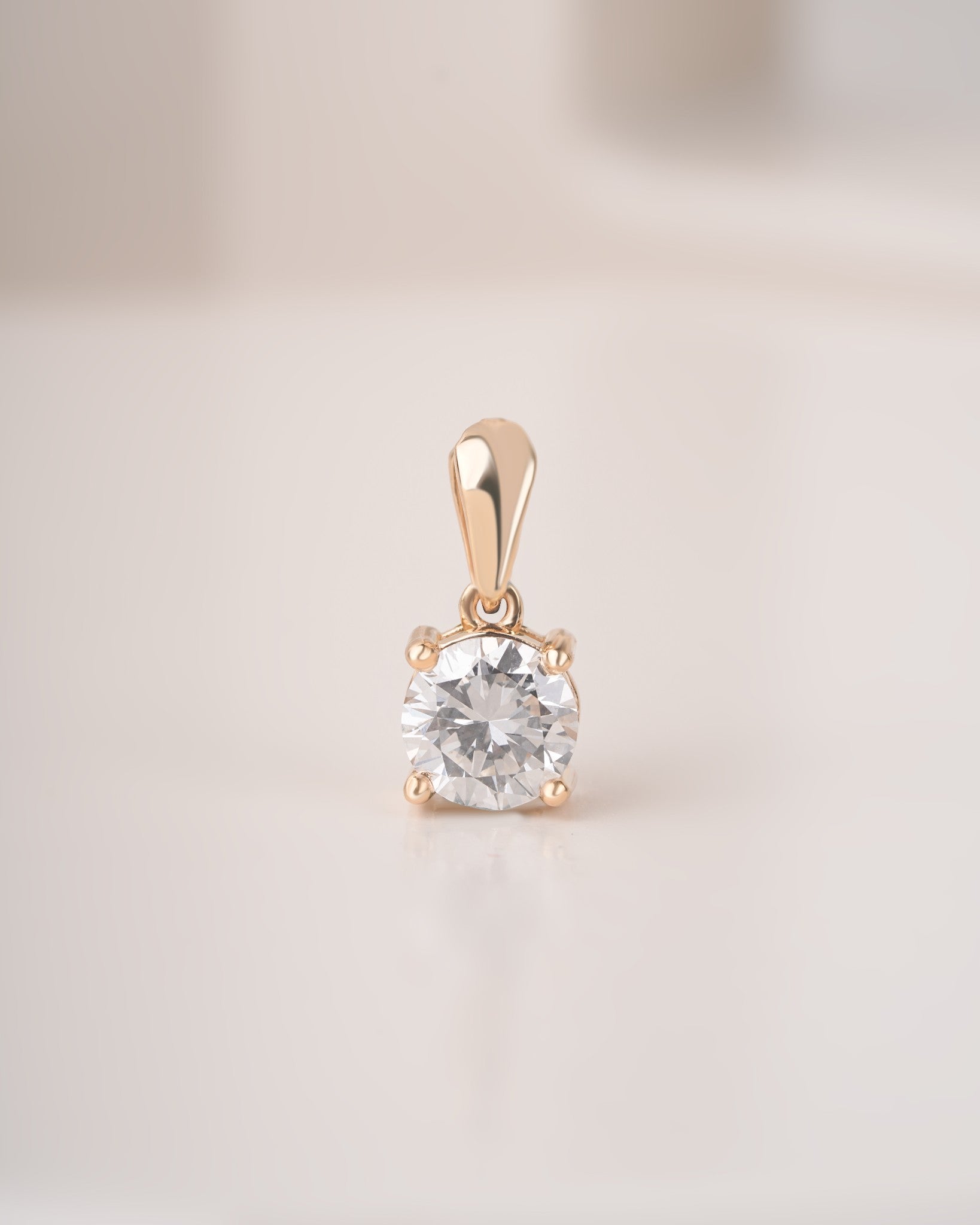 Round cut lab grown diamond solitaire pendant on a white background.