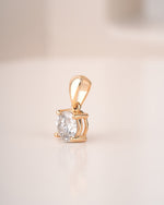Side view of round cut lab grown diamond solitaire pendant on a white background.